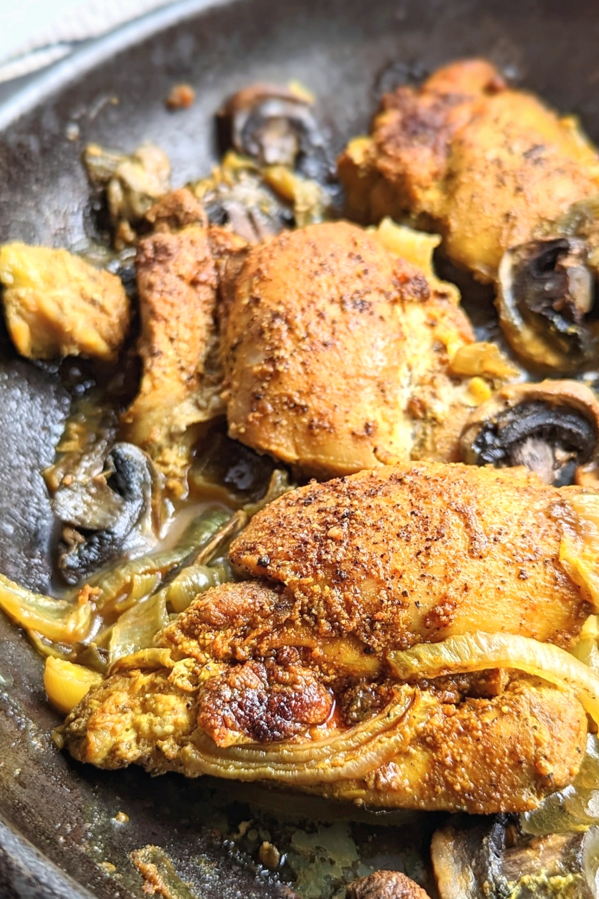 chicken with turmeric and black pepper and mushrooms and onions in a cast iron skillet keto and low carb chicken dinners