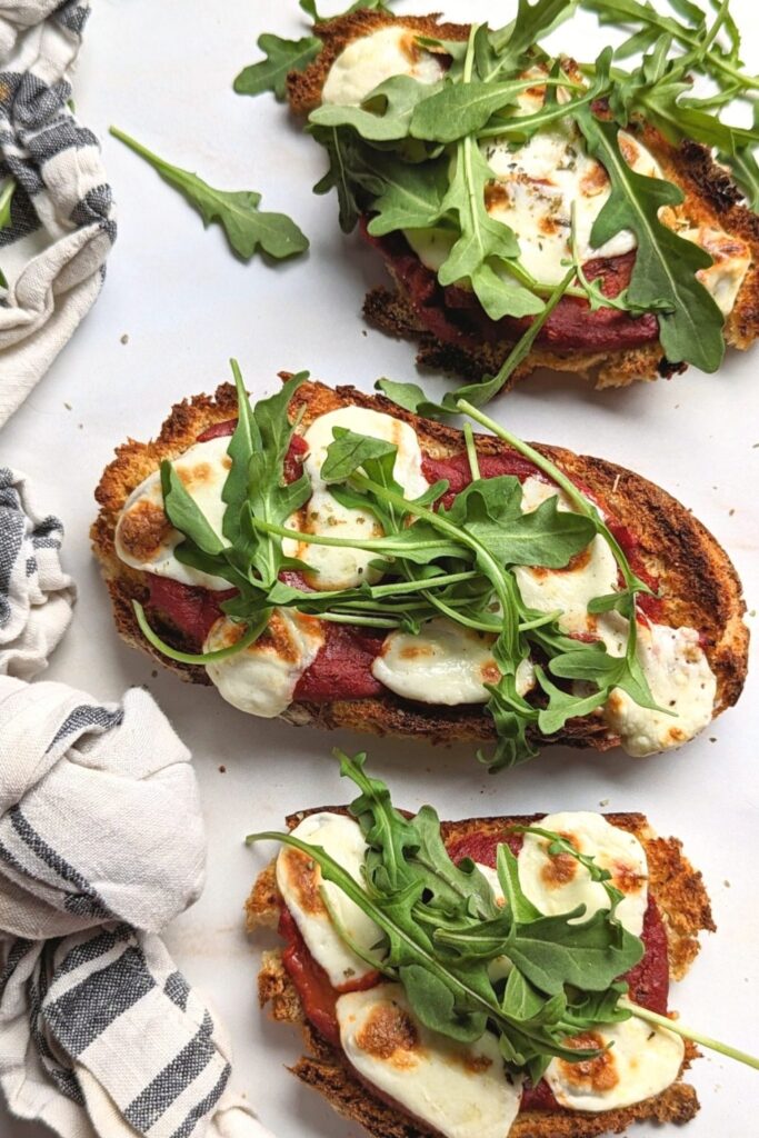 viral pizza toast recipe with tomatoes fresh mozzarella cheese basil and arugula on homemade beer bread toast