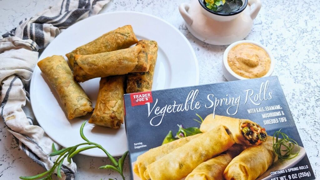a box of trader joe's vegetable spring rolls cooked and air fried on a plate until golden brown