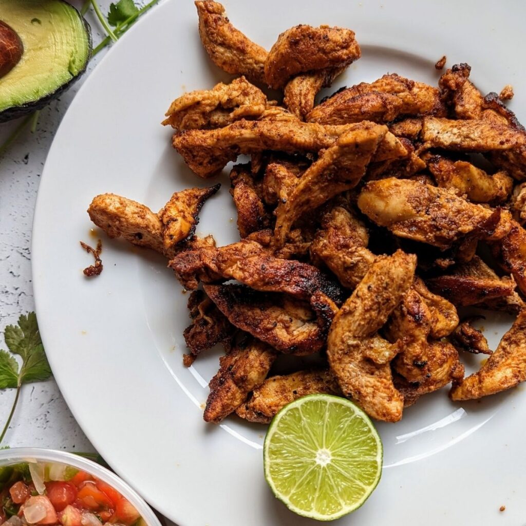chipotle pepper chicken strips with fresh lime wedges