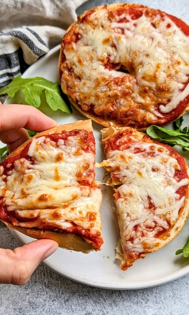 gooey pizza bagels in the air fryer with cheese arugula and pasta sauce on regular bagels