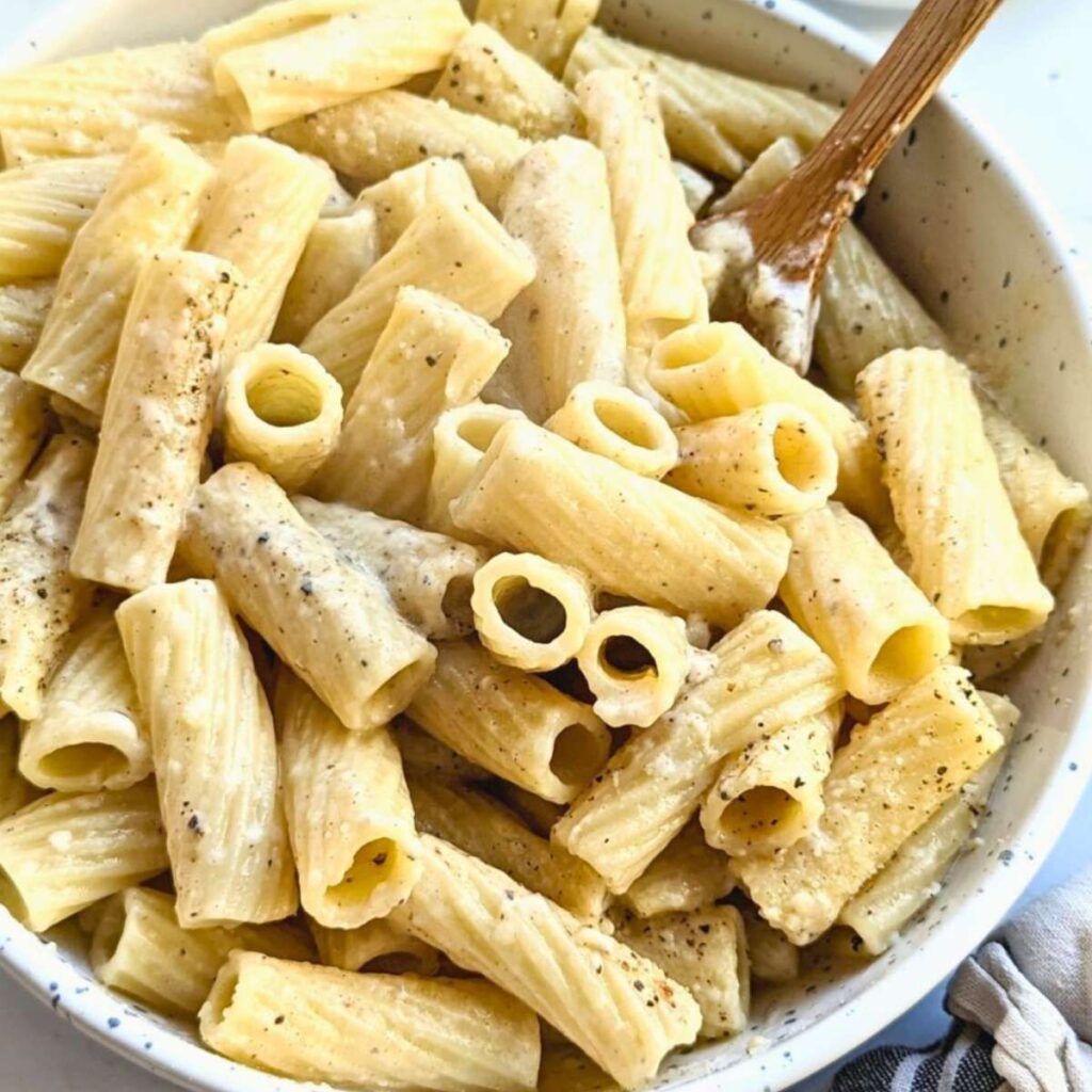 trader joe's cacio e pepe copycat recipe tossed with cooked pasta in a bowl.