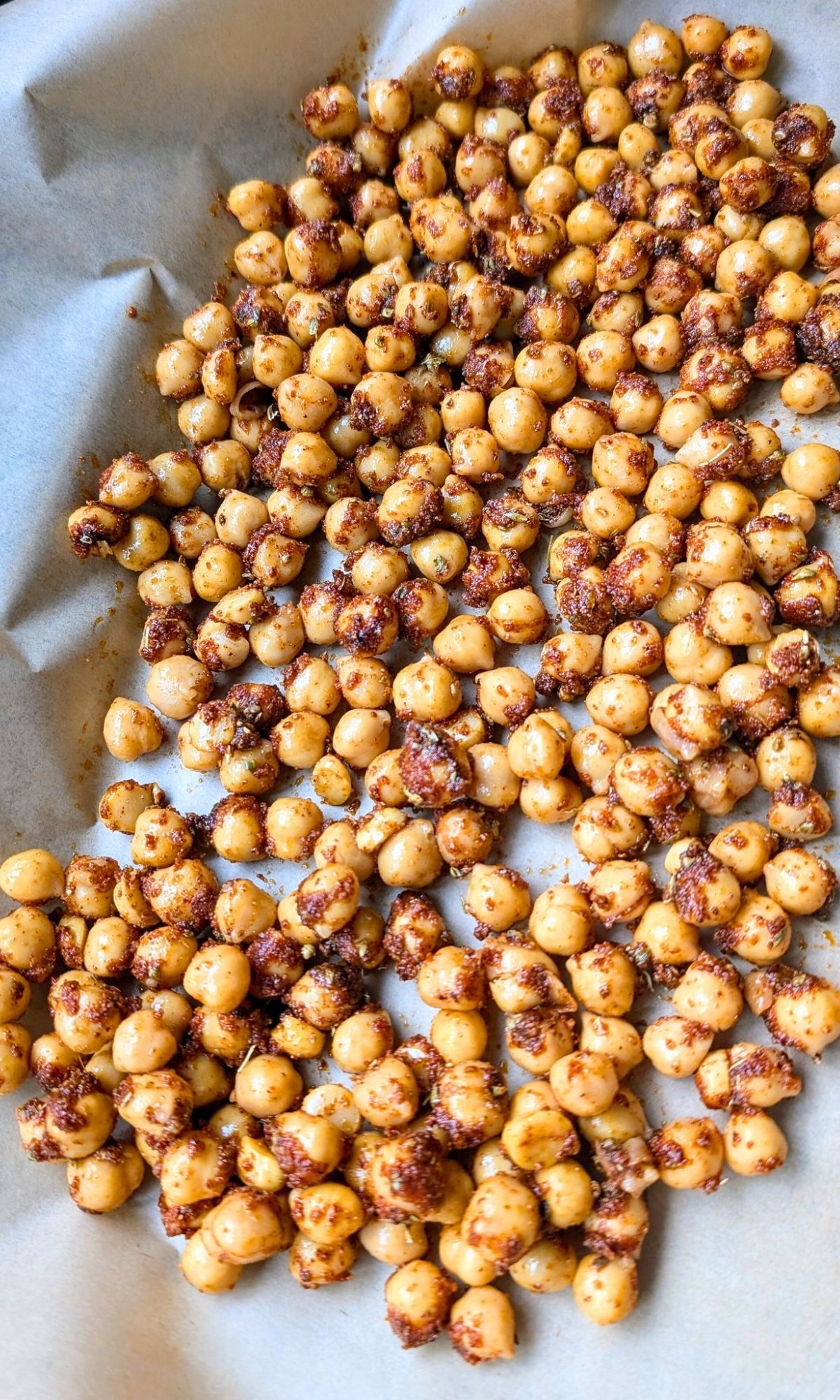 a sheet pan lined with parchment paper topped with shawarma spiced chickpeas or garbanzo beans.