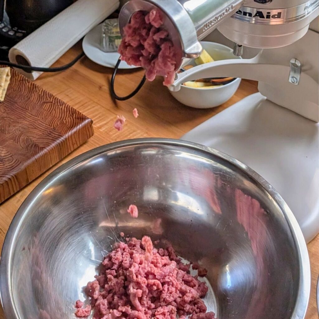 a meat grinder making brisket burger patties from a whole brisket.