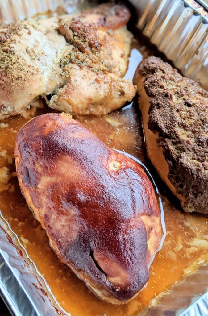 chicken breasts in a pan after being smoked in an electric smoker all day