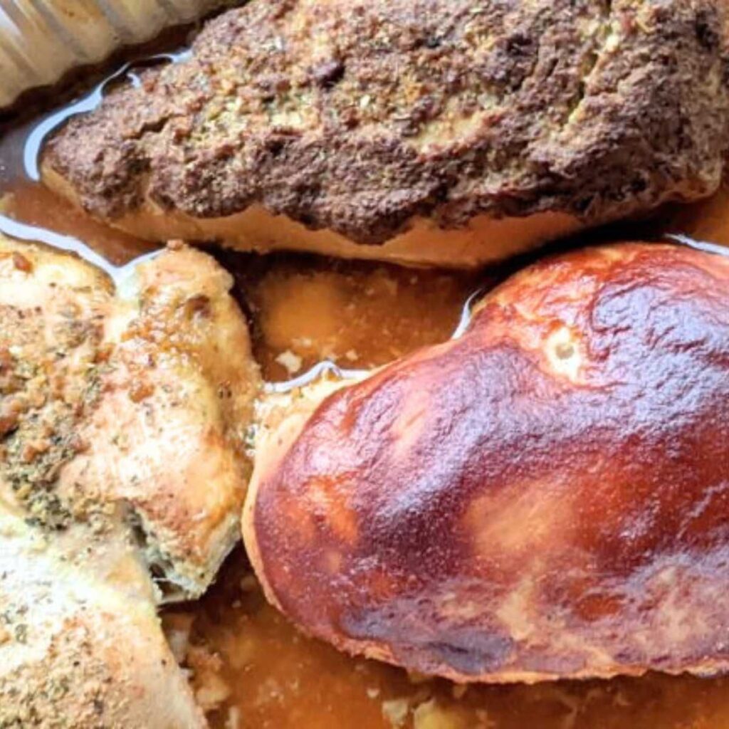 3 smoked chicken breasts in a pan with different spice blends and sauces from honey mustard to bbq.