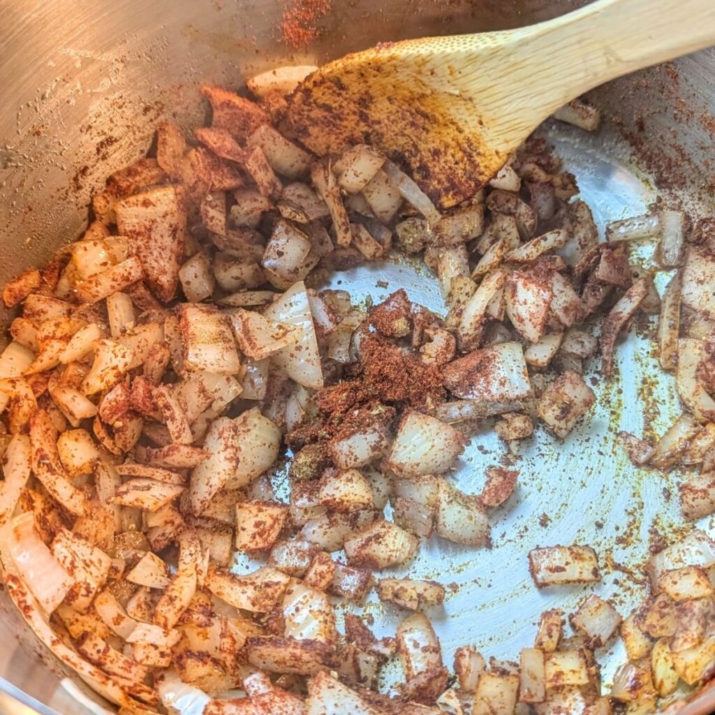 chili spices added to bison meat and onions for buffalo chili recipe.