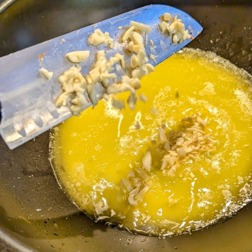 chopped garlic with melted butter in a pan to make chorizo stuffing