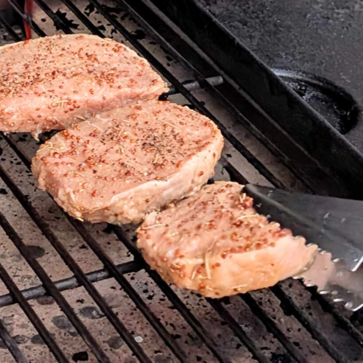 pork chops on the big green egg with tongs