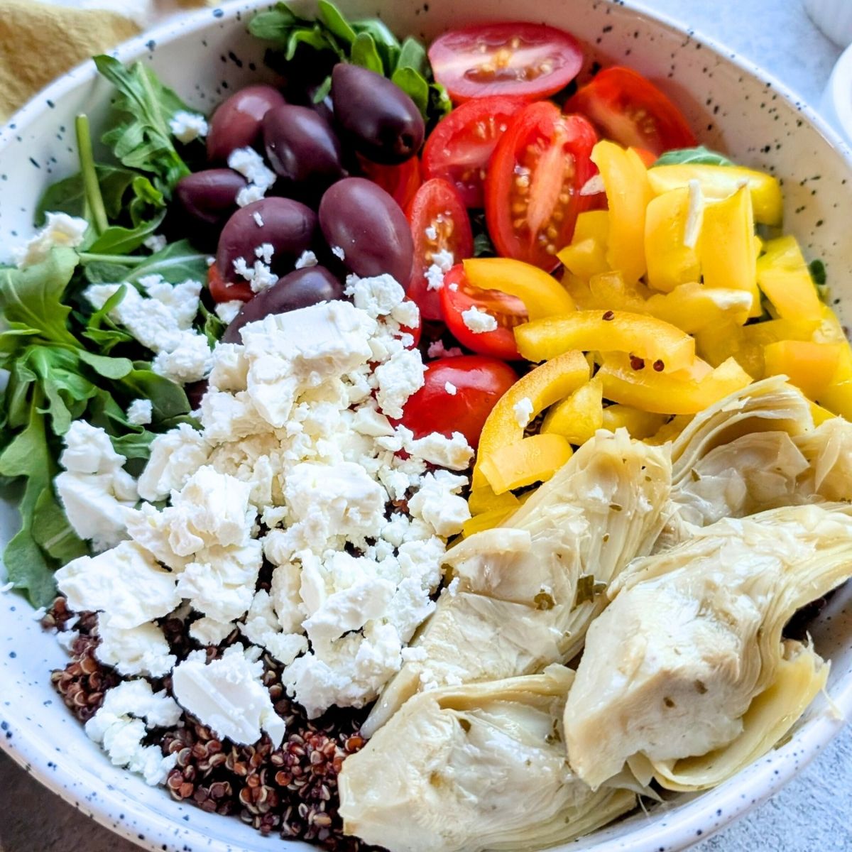 red quinoa feta salad recipe with greek vegetables like bell peppers and tomatoes and olives