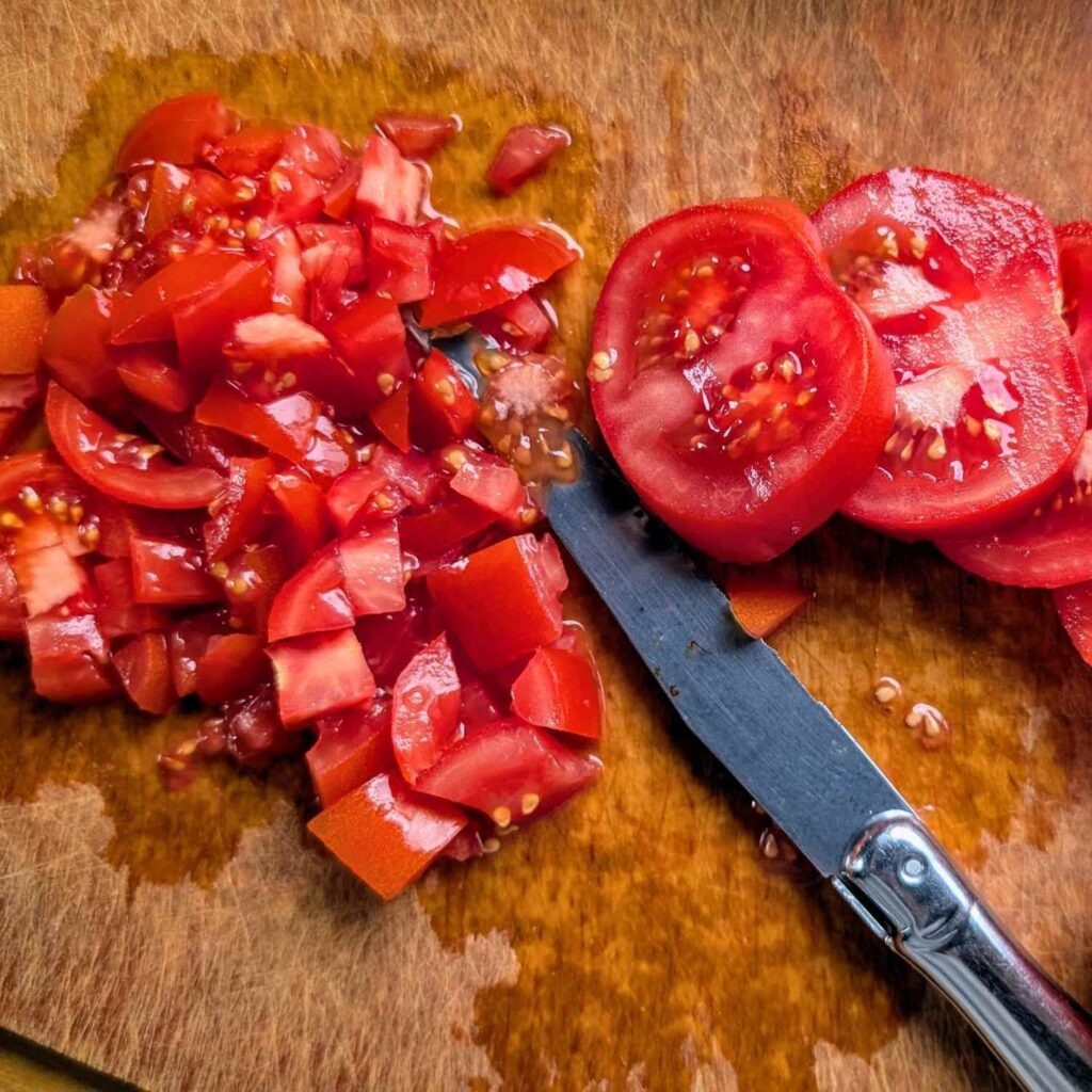 diced tomatoes on a cutting board to make bruschetta copycat trader joe's recipe