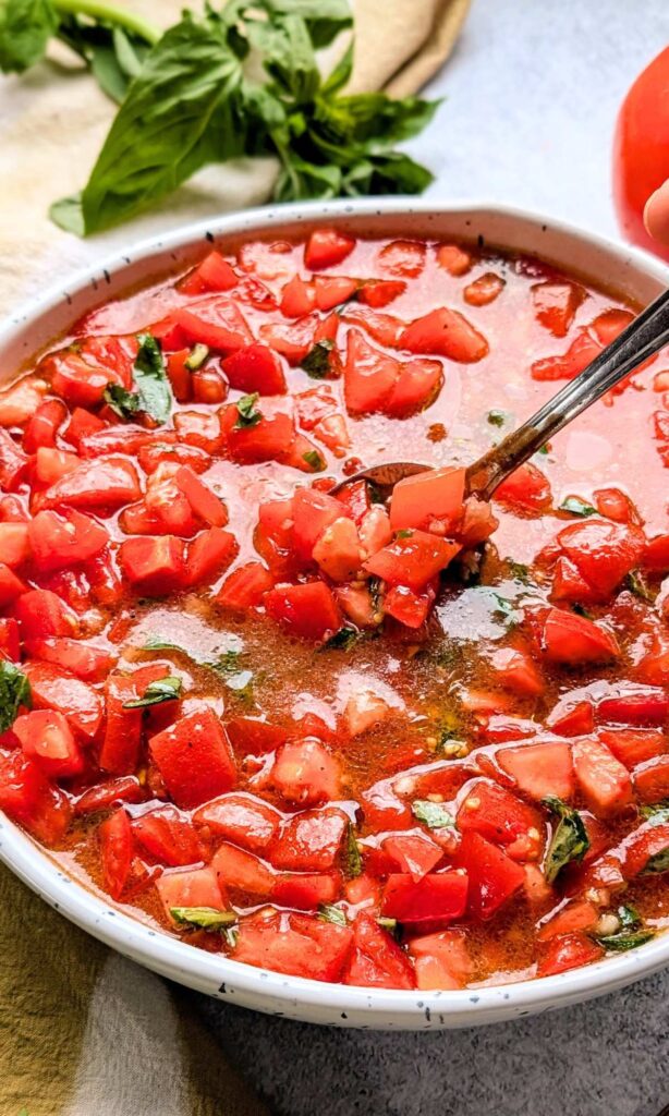 a spoon mixing trader joe's copycat bruschetta with a spoon for an appetizer