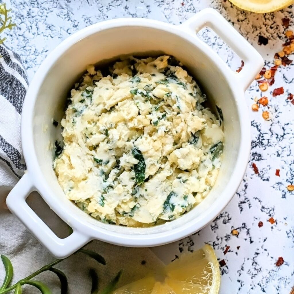 a dish of garlic butter spread with parmesan cheese, chives, and parsley.