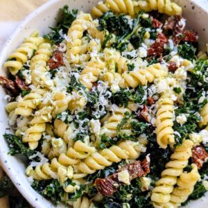 kale pasta salad with sun-dried tomatoes and parmesan cheese with feta and garlic dressing