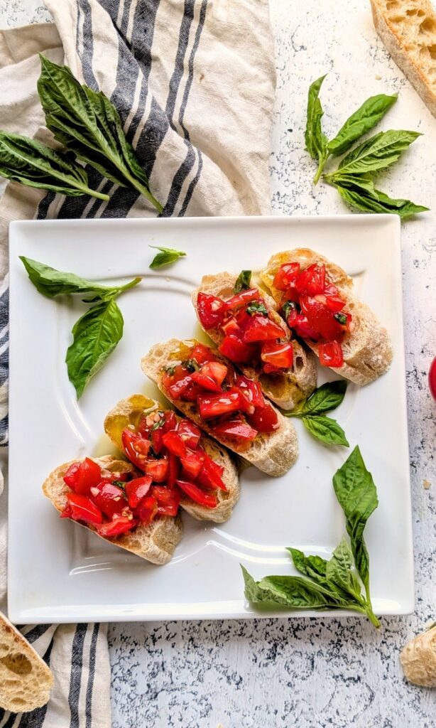 a plate of fresh pomodoro bruschetta on sliced italian bread for a tasty olive garden copycat recipe