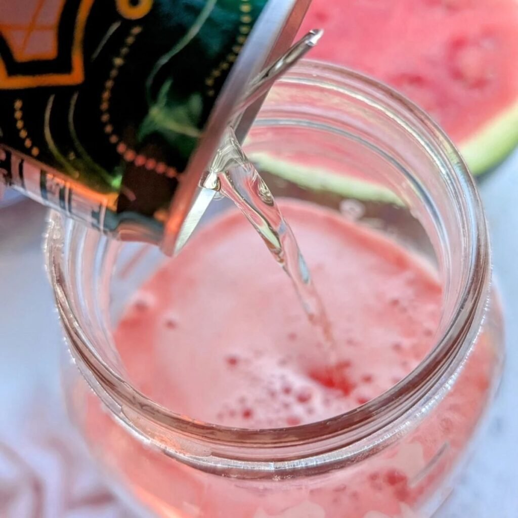 ginger ale being poured into water melon sangria for extra sweetness and taste