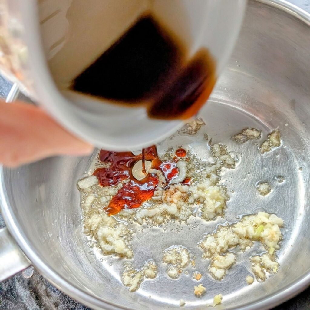 soy sauce as the base of asian soup with water and dumplings