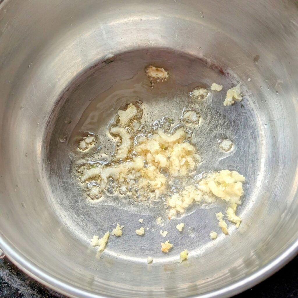 toasted sesame oil in in a pot with minced garlic for the base of dumpling bok choy soup