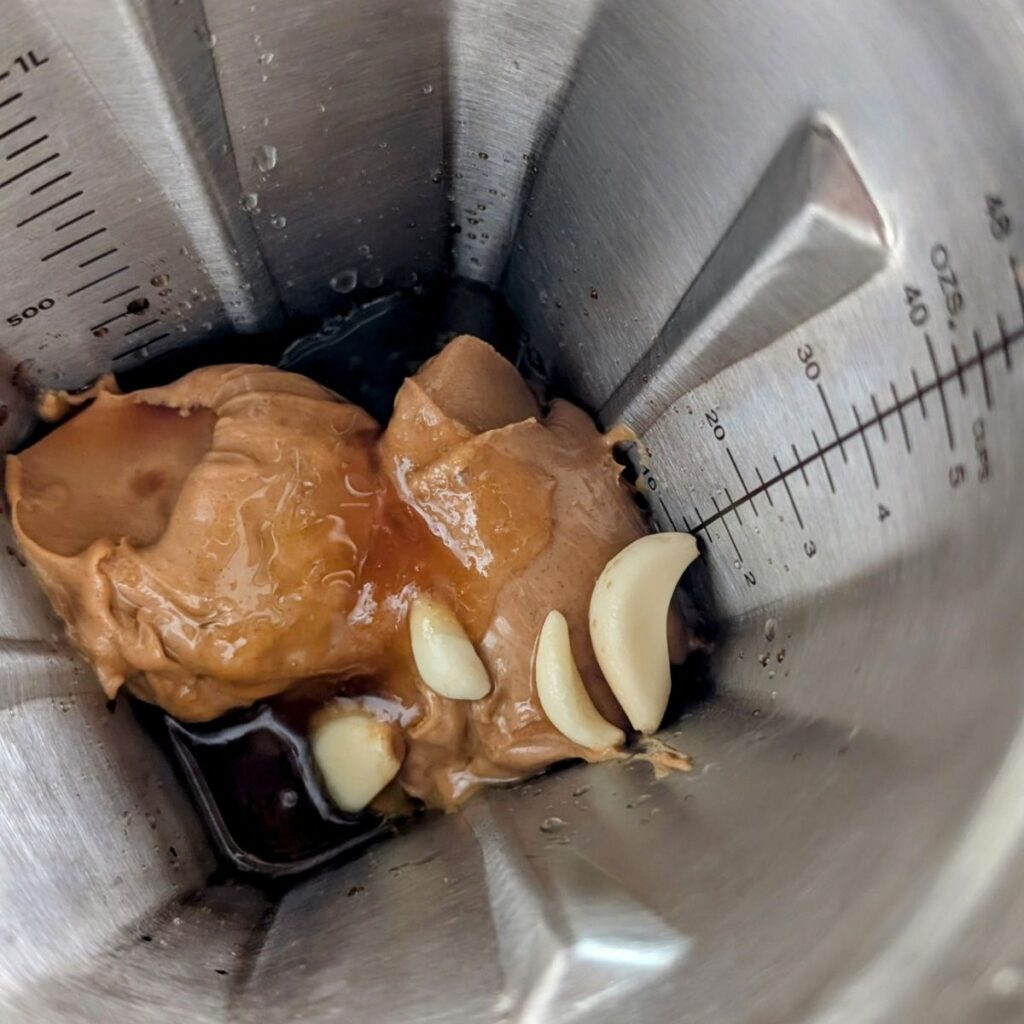a blender full of peanut butter garlic and honey to make peanut sauce 