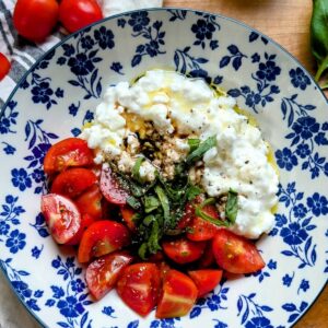 caprese cottage cheese bowl recipe with high protein low fat cottage cheese and tomatoes and basil and balsamic vinaigrette.