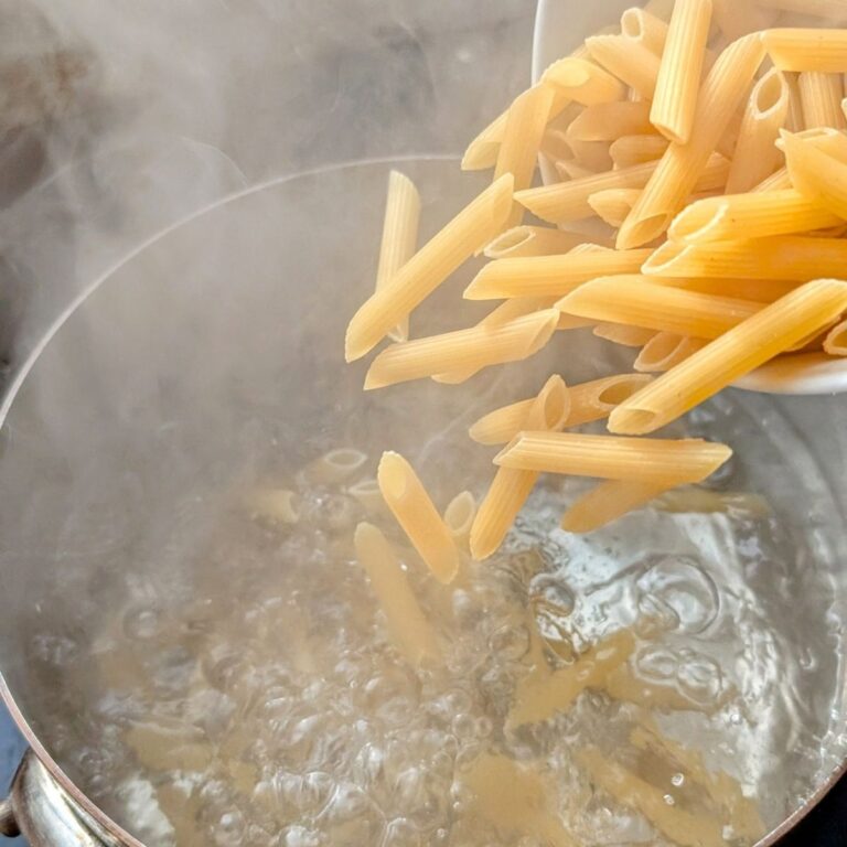 penne pasta being cooked in a pot for penne alla vodka carmines copycat recipe