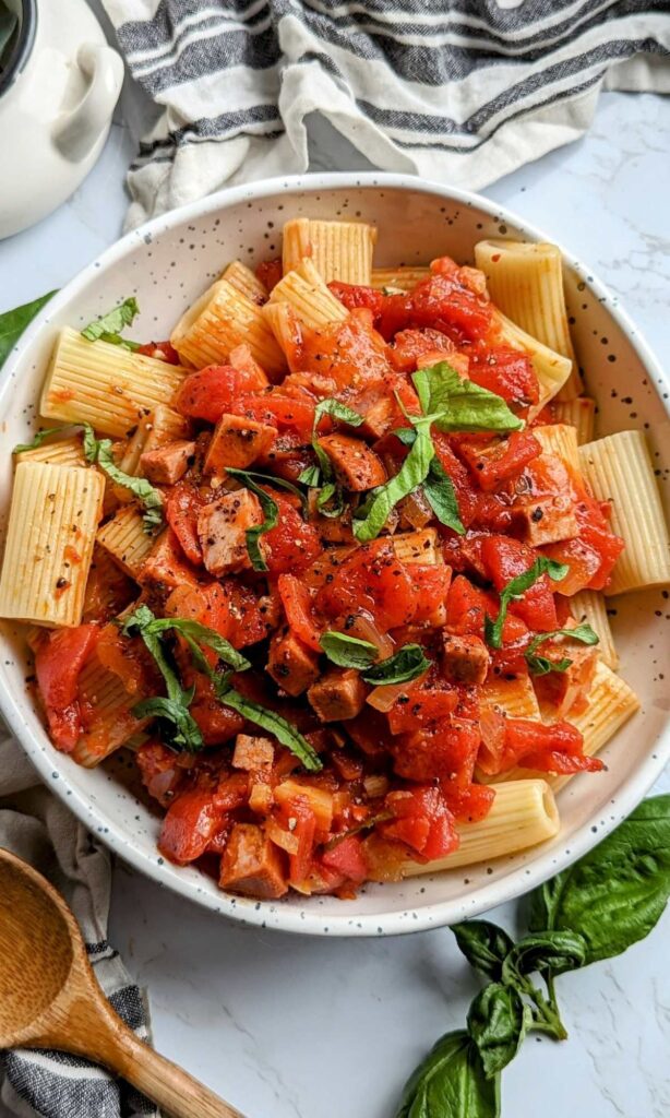 a bowl of dairy free chorizo pasta with basil and rigatoni noodles.