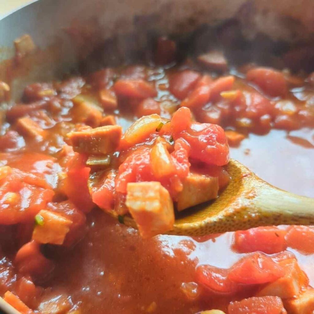 a spoon full of chorizo pasta without cream and diced canned tomatoes.