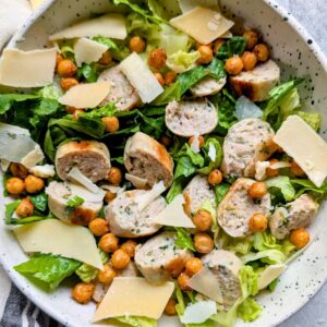 chicken sausage caesar salad with chickpeas and parmesan cheese and creamy dressing